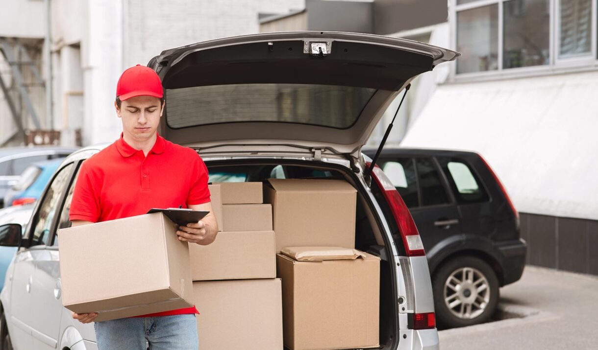 courier holds big box and checks address on tablet eku5v8b.jpg