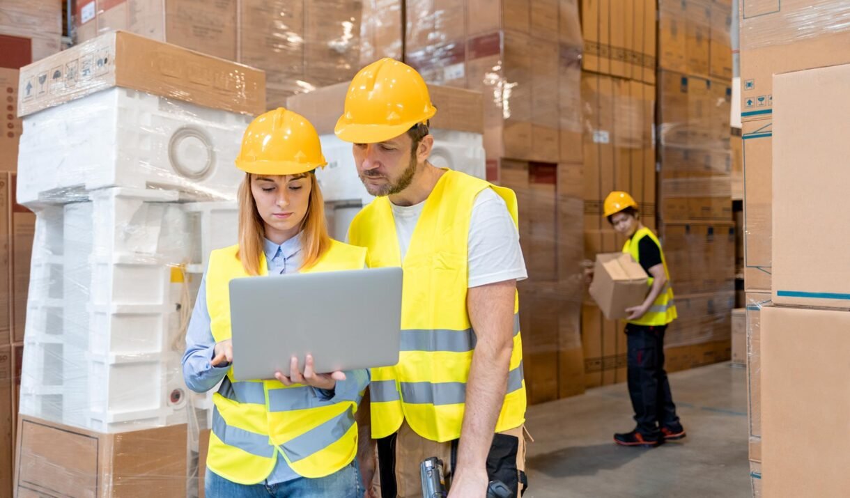 warehouse workers consult delivery plans using lap 3e6pbvc.jpg
